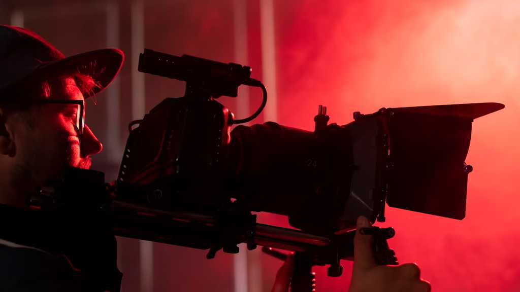 Man on a Camera on a stage under a red light